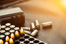 9mm bullet shells  placed near 9mm pistol on black leather background, soft and selective focus.