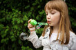 © Анна Молько - girl in a white denim jacket blowing soap bubbles