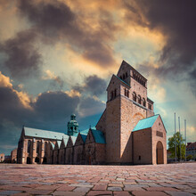 Beautiful View Of St. Mary's Cathedral In Hildesheim, Germany Under Gray And Gold Clouds
