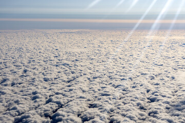 Wall Mural - Clouds sky background with white volumetric foamy clouds in the blue sky. View from the plane. Background