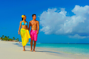 Couple at the beach, interracial, walking on the shore, holding hands