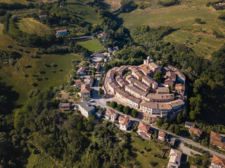 Italy, May 2021. Aerial view of the medieval village of Serrungarina in the province of Pesaro and Urbino in the Marche region. You can also see the green hills around.