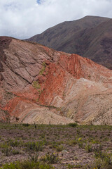 Travel. Altiplano landscape. View of the arid desert, colorful rock and sandstone formations under a beautiful blue sky with clouds.