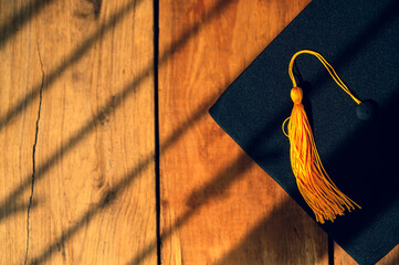 Black Graduation Hat placed on Old wood background