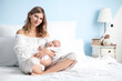 © Pixel-Shot - Happy mother and cute little baby on bed at home