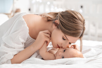 Poster - Happy mother and cute little baby on bed at home