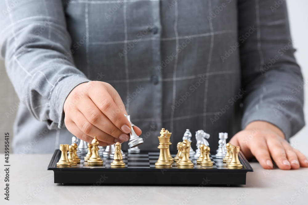 Woman playing chess on light table