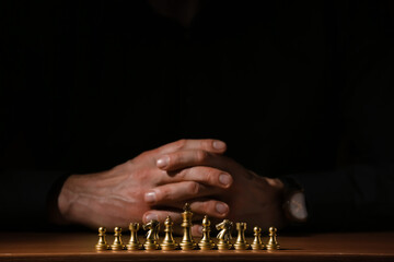 Wall Mural - Man playing chess on dark background, closeup