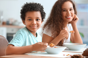 Canvas Print - Little boy with mother eating cornflakes at home