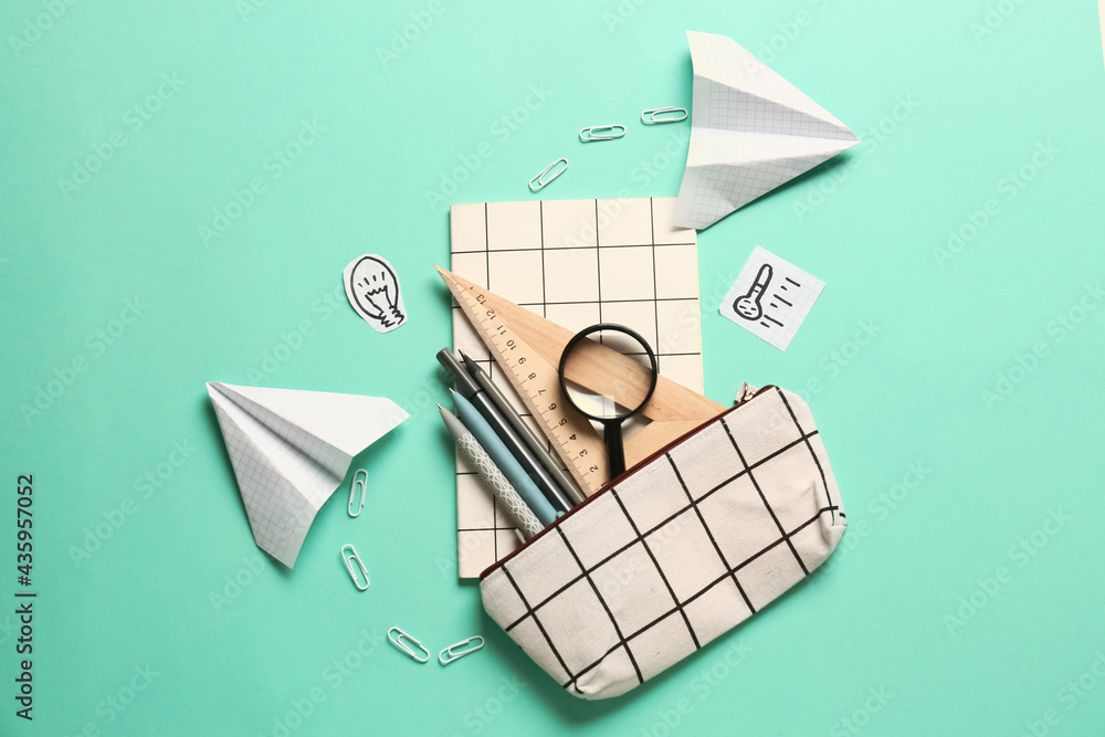 Pencil case and stationery on color background