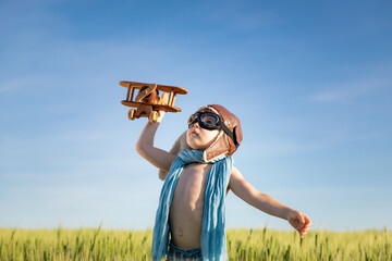 Canvas Print - Happy child with airplane playing outdoor in summer