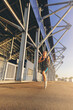 © Panumas - Sporty woman running outdoor beside the stadium. Fit female fitness runner jogging in the city