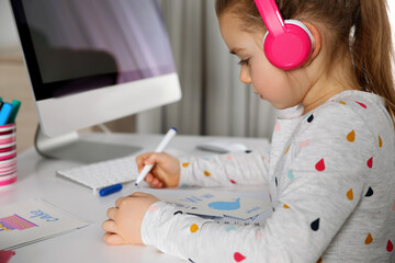 Canvas Print - Little girl learning English indoors at online lesson, closeup