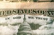 A macro close up photo emphasizing the inscription In God We Trust printed on the back of a United States ten dollar bill with selective focus on the words In God We Trust.