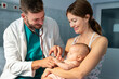 © NDABCREATIVITY - Pediatrician doctor medical examining little smiling baby, held by mother