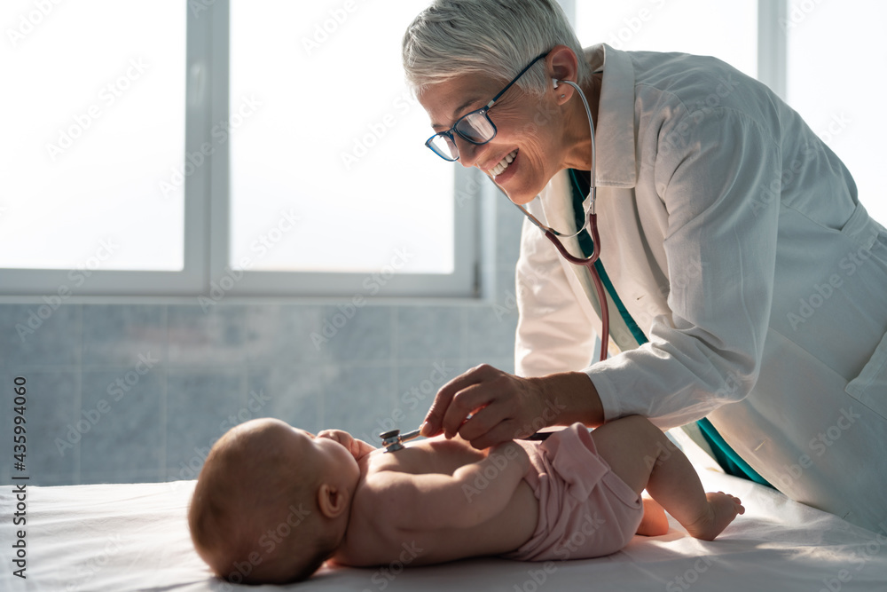 Pediatric doctor exams little baby. Health care, medical examination, people concept - obrazy, fototapety, plakaty 