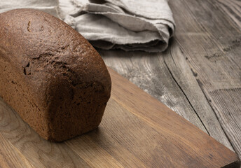 baked rectangular rye flour bread on brown board