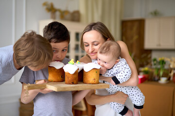 Preparing for Holly holiday. Waist up portrait of happy mom showing just baked delicious Easter cake with topping to her female child. High quality photo