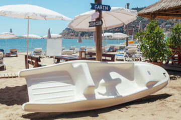 a carbon fiber boat lies on the sand near the sea