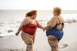 © DisobeyArt - Plus size friends walking on the beach having fun during summer vacation - Focus on right woman back