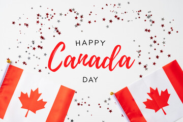 Wall Mural - Happy Canada Day banner mockup. Canadian flags and confetti on white table. Flat lay, top view, copy space.