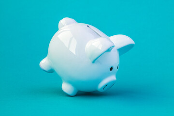 Wall Mural - White piggy bank falling on blue background