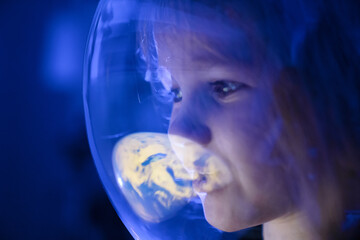 Wall Mural - girl dreams of becoming astronaut and flying into space. reflection of planet