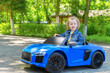 © Denis Rozhnovsky - The child is driving a toy car in the park.