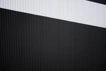 Wall Mural - Black and white corrugated iron sheet used as a facade of a warehouse or factory. Texture of a seamless corrugated zinc sheet metal aluminum facade. Architecture. Metal texture.