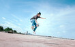 © 2B - Teenager skateboarder does an ollie trick on background of blue sky gradient