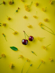 Wall Mural - ripe cherries on yellow background top view. Pattern of fresh red  cherries with sprig . ummer Creative layout. flat lay