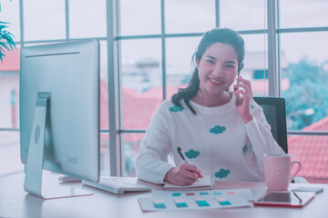 Asian woman staff working,smartphone and pc computer,happy smiling at home office,remote presenting marketing plan report online web conference video call application to business team office to work