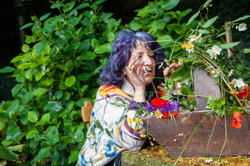 Poster - Senior blue-haired female taking care of beautiful flowers in a wooden pot