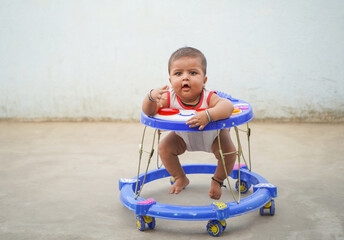 Little child in the baby walker, Indian kid learning to walk