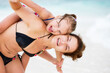 Happy mother and little daughter having fun on sand beach on Maldives at summer vacation. Family on the beach concept.