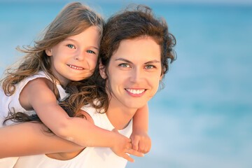 Wall Mural - Portrait of happy mother and little daughter on ocean beach on Maldives at summer vacation. Family on the beach concept.