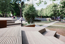 
Modern Benches And Wooden Stairs In City On A Sunny Day. Public Places In City Park. Selective Focus, Blurred Background.