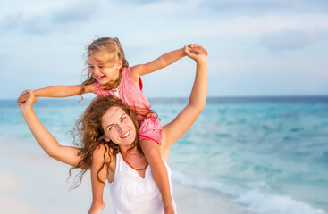 Wall Mural - Happy mother and little daughter having fun on beach on Maldives at summer vacation. Family on the beach concept.