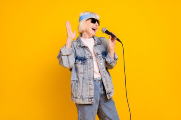 Sticker - Photo portrait of senior woman wearing sunglass denim outfit singing in microphone on stage isolated vivid yellow color background