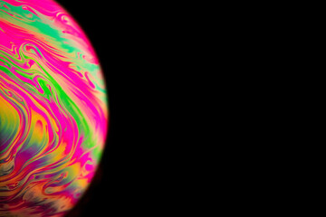 Wall Mural - Bubbles macro. Globe planet earth in galaxy universe space with abstract sun on black background. Macro of oil mixed with water.