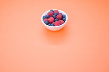 Canvas Print - Closeup shot of fresh blueberry and raspberry on a white bowl