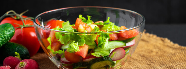 Wall Mural - Fresh vegetable salad in a glass bowl on dark background. Vegan organic food, seasonal summer dish.