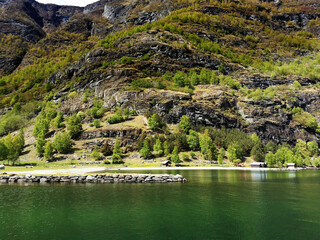 Wall Mural - Scenic shot of a lake in a village Flam, Norway, surrounded by mountains and houses on the shore