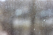 Streaks and traces of raindrops on the dirty window glass. Blurry and unfocused background.