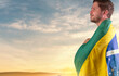 Brazilian man with Brazilian flag looking at the horizon
