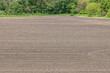 A farm field with exposed soil from conventional tillage.