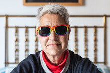 Portrait Of Lesbian Older Lady With Short Gray Hair Wearing Rainbow Gay Pride Flag Sunglasses.