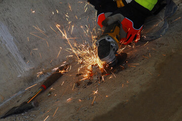 background, the person cutting iron, cutting disc, sparks when cutting iron, angle grinder, battery, hands, work gloves, sparks, no face