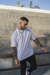 Poster - Spanish man with tattoos in casual style near the stairs