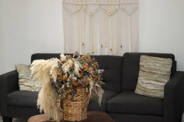 tiny house apartment with a gray armchair for two and decorative coffee yellow and orange centerpiece with a cactus to match and a woven macrame on the white wall